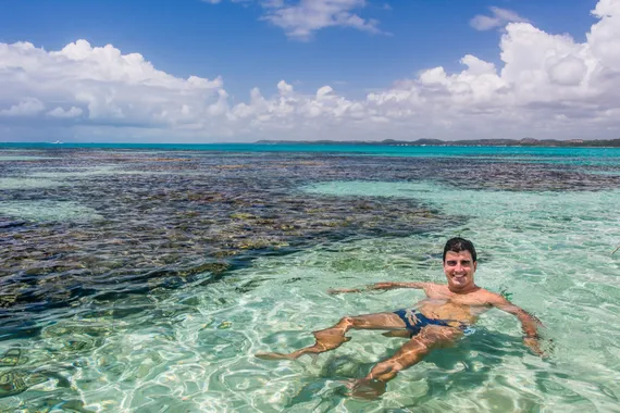 Homem relaxando nas águas cristalinas próximo aos corais de Maragogi